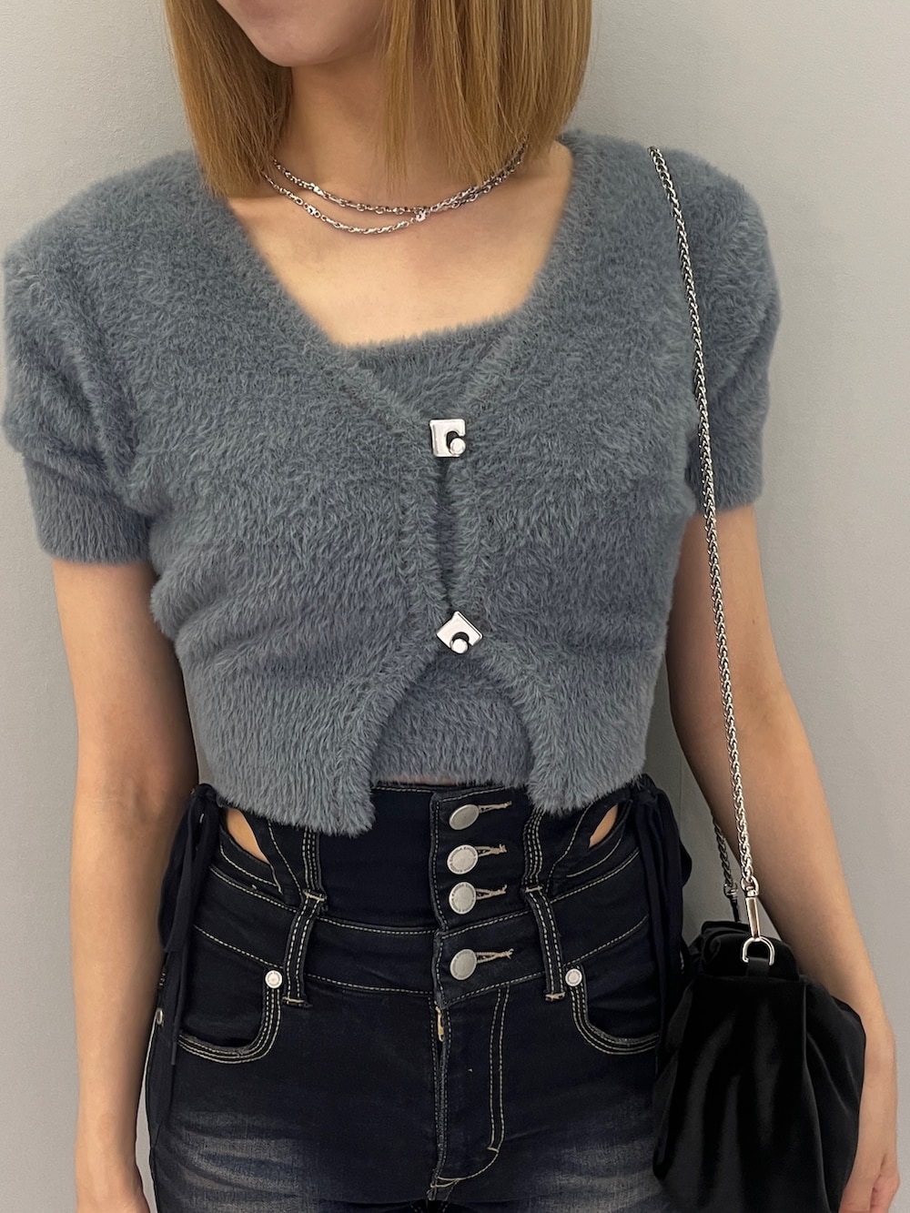 ブルー系のニット/セーター、ブルー系のデニムパンツ、ブラック系のサンダルを着用したレディースの夏コーディネートの4枚目の写真