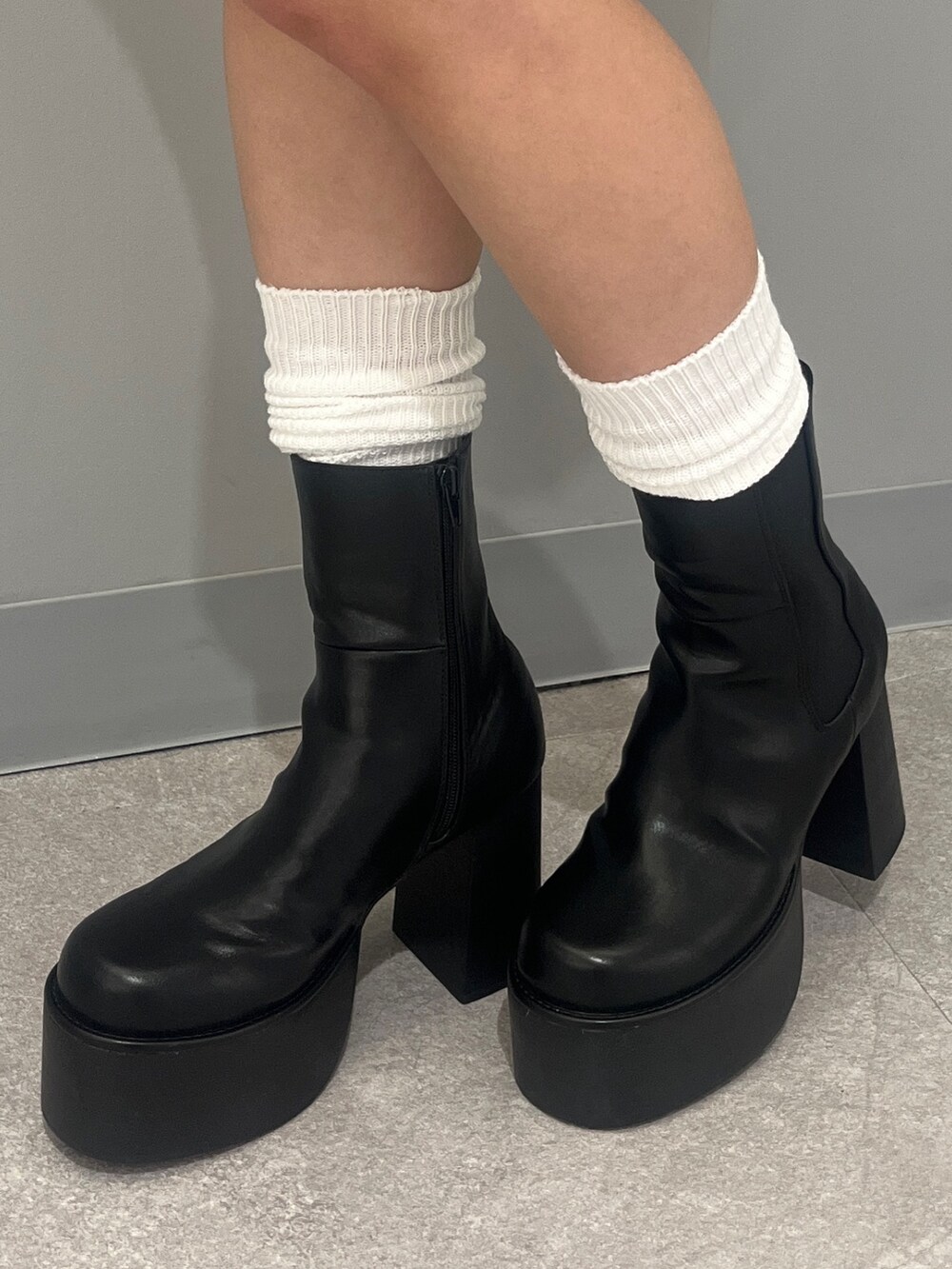 ブルー系のデニムパンツ、ブラック系のブーツ、グレー系のニット/セーターを着用したレディースの秋コーディネートの9枚目の写真