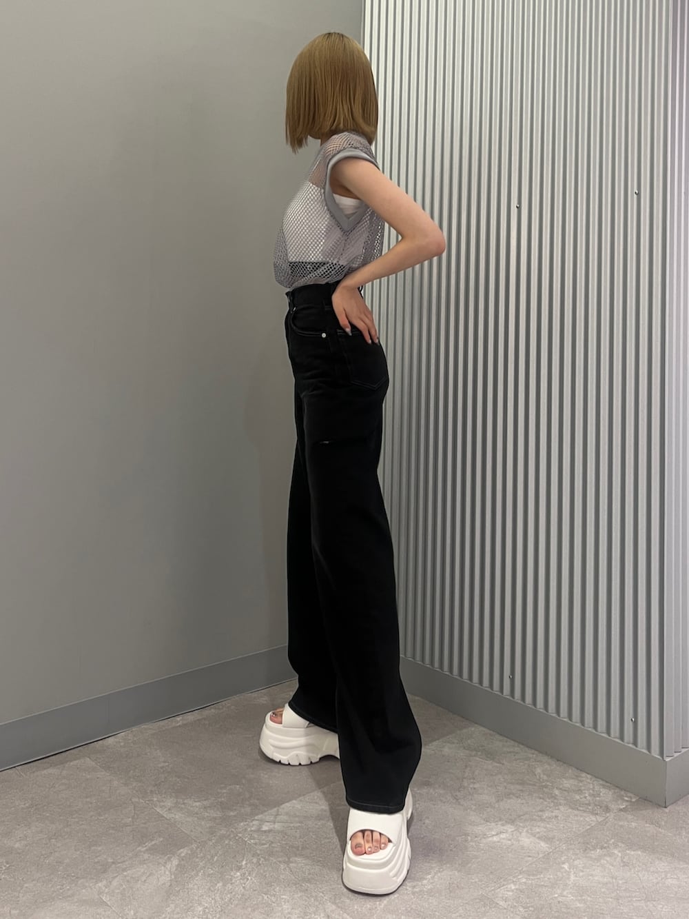 ブラック系のデニムパンツ、グレー系のTシャツ/カットソー、ホワイト系のサンダルを着用したレディースの夏コーディネートの2枚目の写真