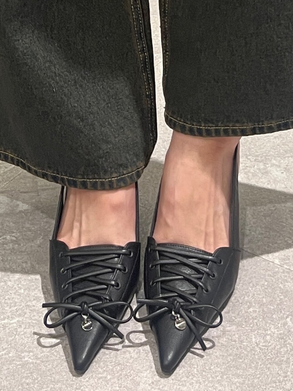 ブラック系のその他パンツ、ブラック系のハンドバッグ、ホワイト系のパンプスを着用したレディースの春コーディネートの6枚目の写真
