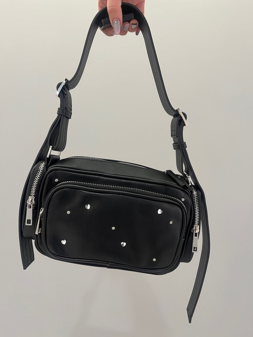 ブルー系のニット/セーター、ブラック系のデニムパンツ、ブラック系のショルダーバッグを着用したレディースの冬コーディネートの6枚目の写真