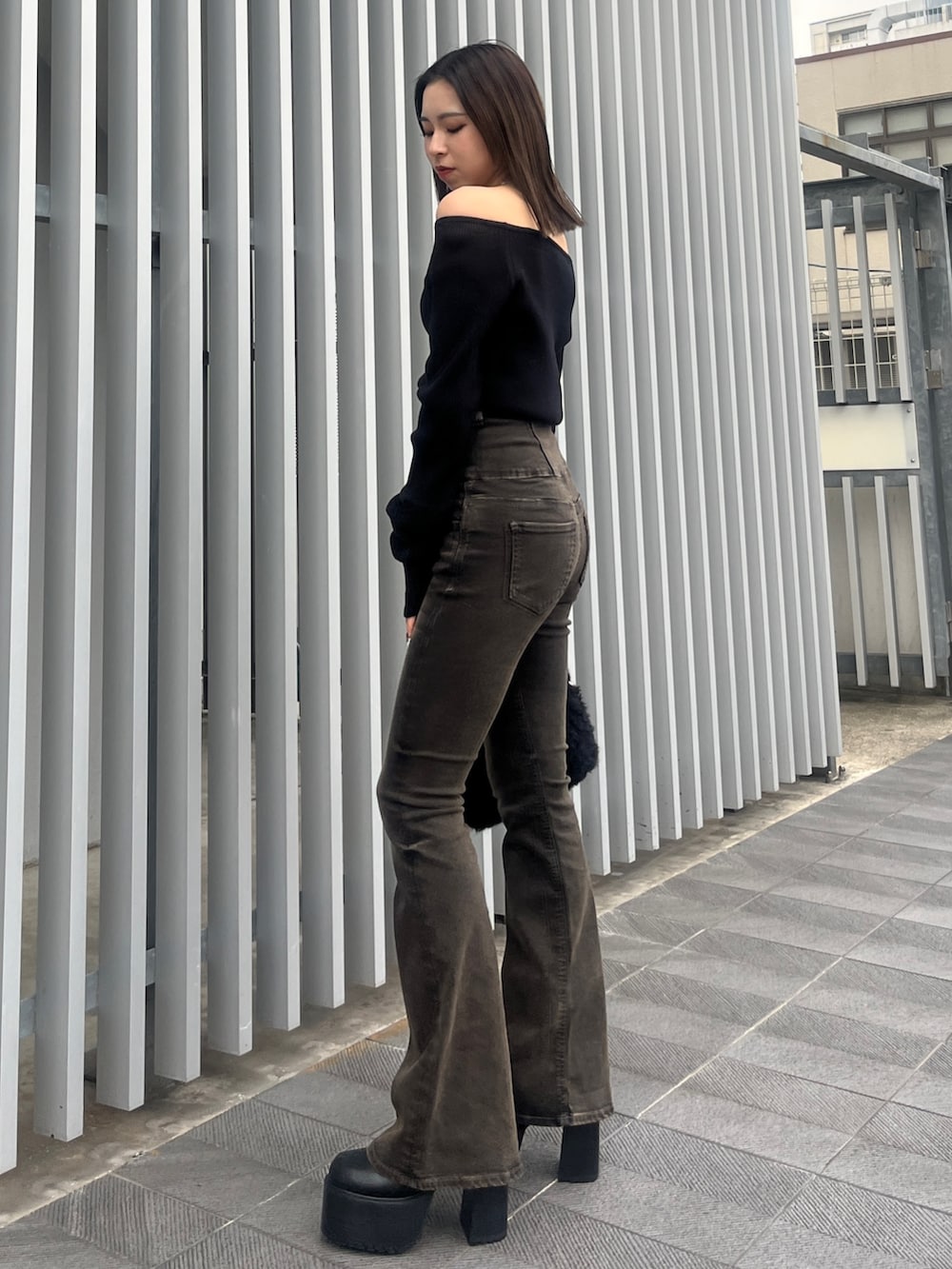 ブラック系のデニムパンツ、ブラウン系のブルゾン、ブラック系のハンドバッグを着用したレディースの秋コーディネートの2枚目の写真