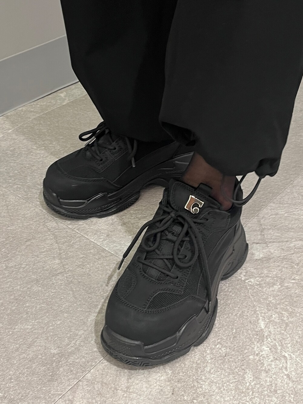 ブラック系のブルゾン、グリーン系のキャミソール、ブラック系のその他パンツを着用したレディースの冬コーディネートの6枚目の写真