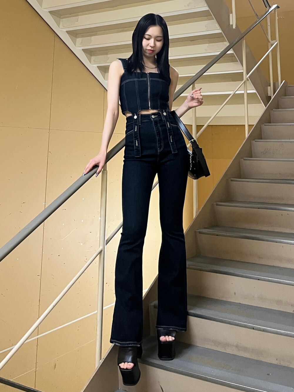 ブラック系のシャツ/ブラウス、ブルー系のサロペット/オーバーオール、ブラック系のハンドバッグを着用したレディースの春コーディネートの4枚目の写真