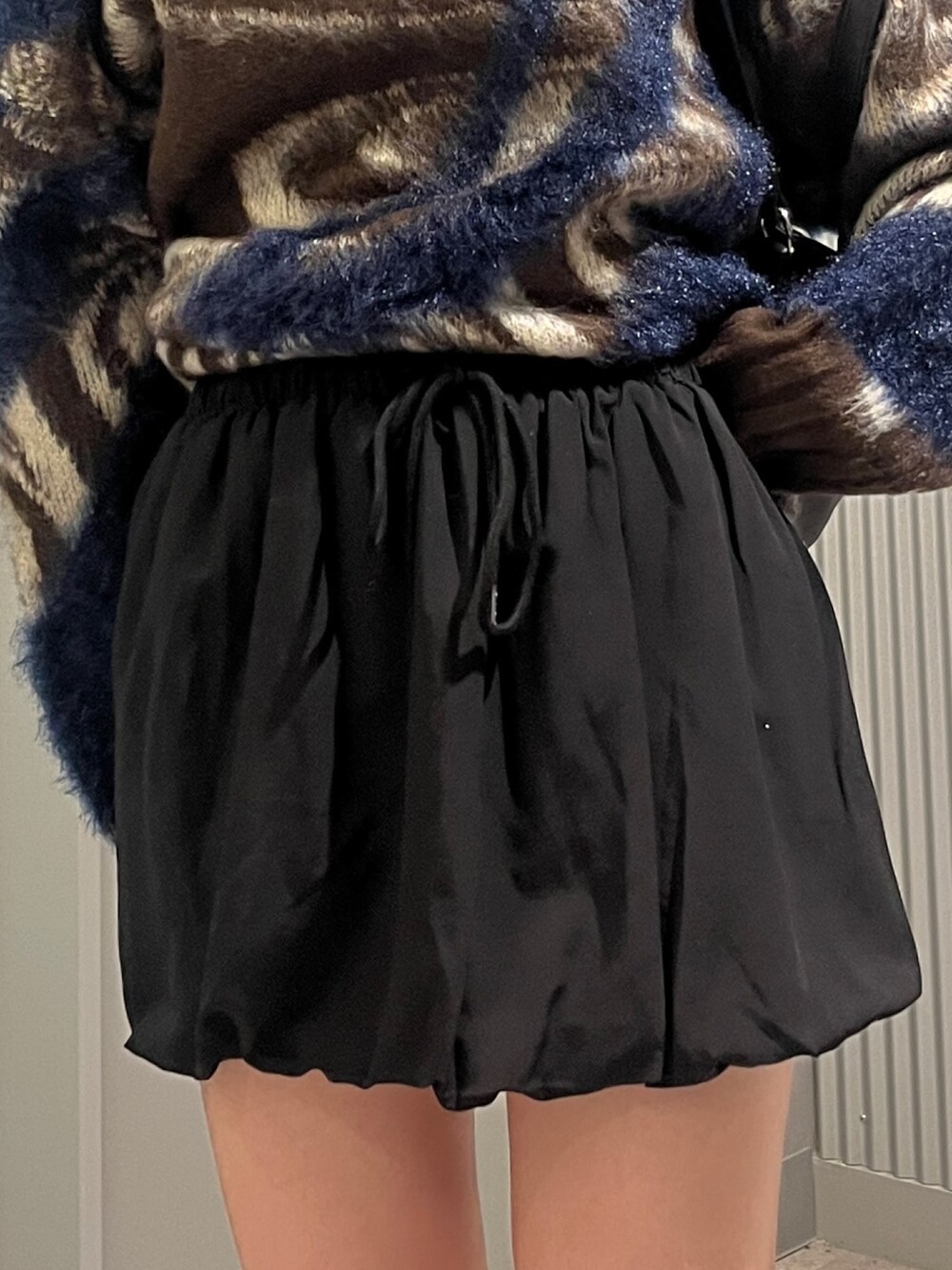 ブラウン系のニット/セーター、ブラック系のショルダーバッグ、ブラック系のスカートを着用したレディースの秋コーディネートの5枚目の写真