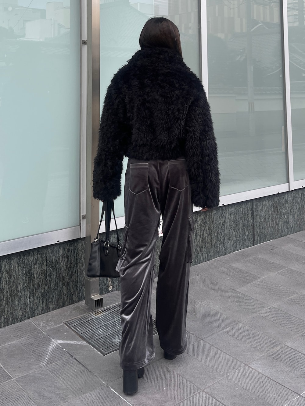 ブラック系のニット/セーター、ブラック系のブルゾン、グレー系のカーゴパンツを着用したレディースの秋コーディネートの3枚目の写真