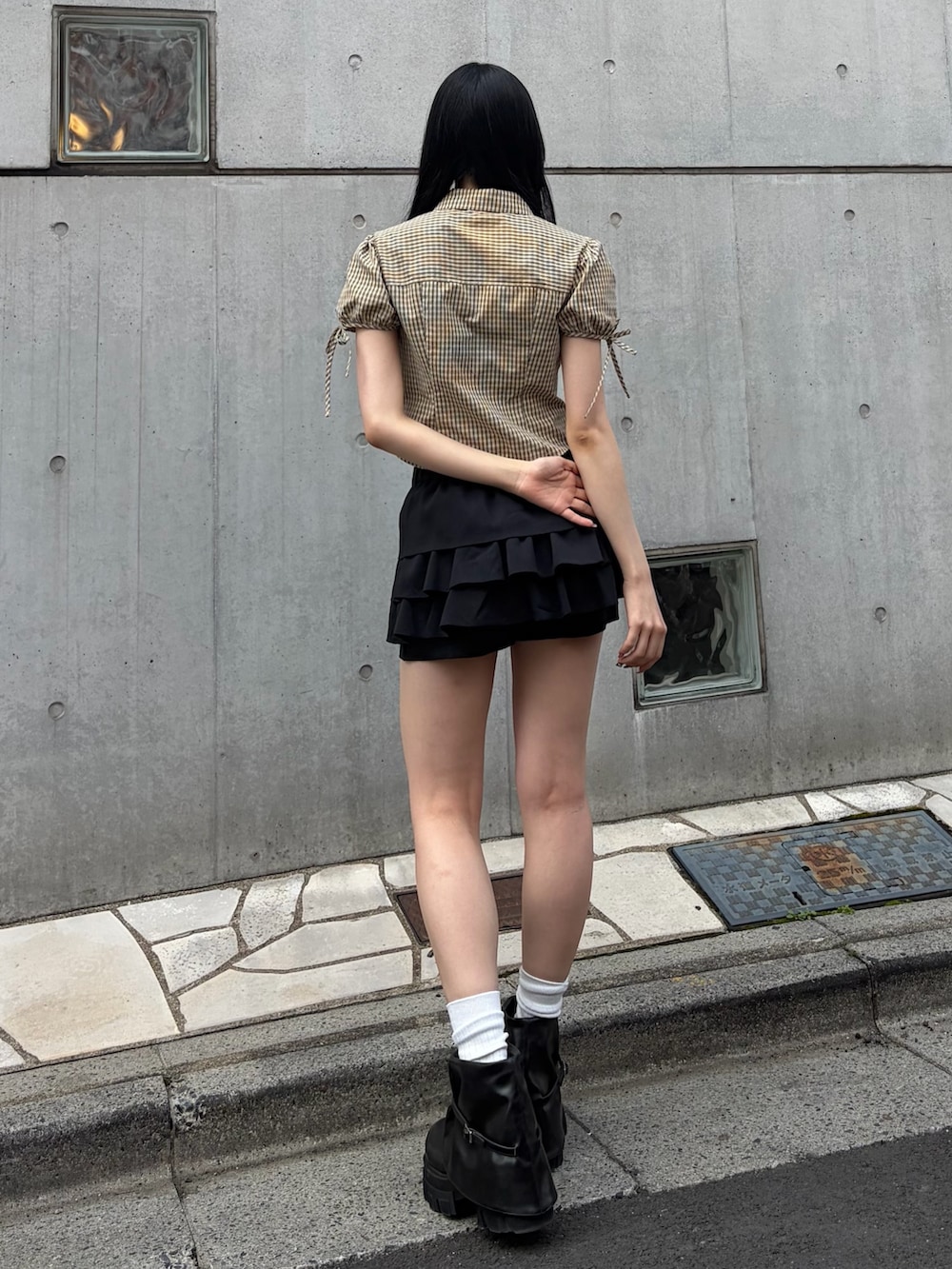 ベージュ系のシャツ/ブラウス、ブラック系のスカート、ブラック系のブーツを着用したレディースの春コーディネートの3枚目の写真