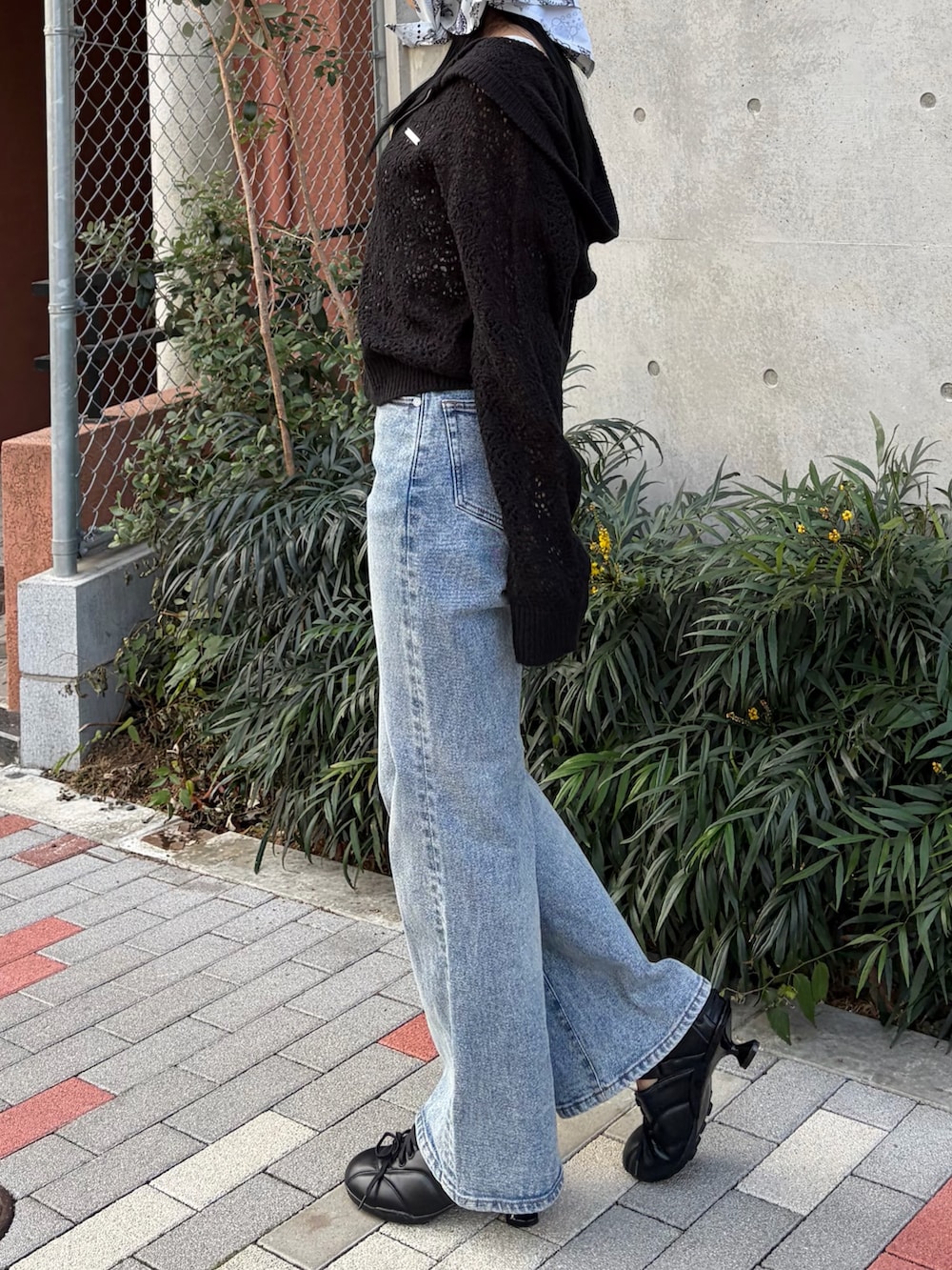 ブラック系のパーカー、ホワイト系のニット/セーター、ブルー系のデニムパンツを着用したレディースの春コーディネートの2枚目の写真