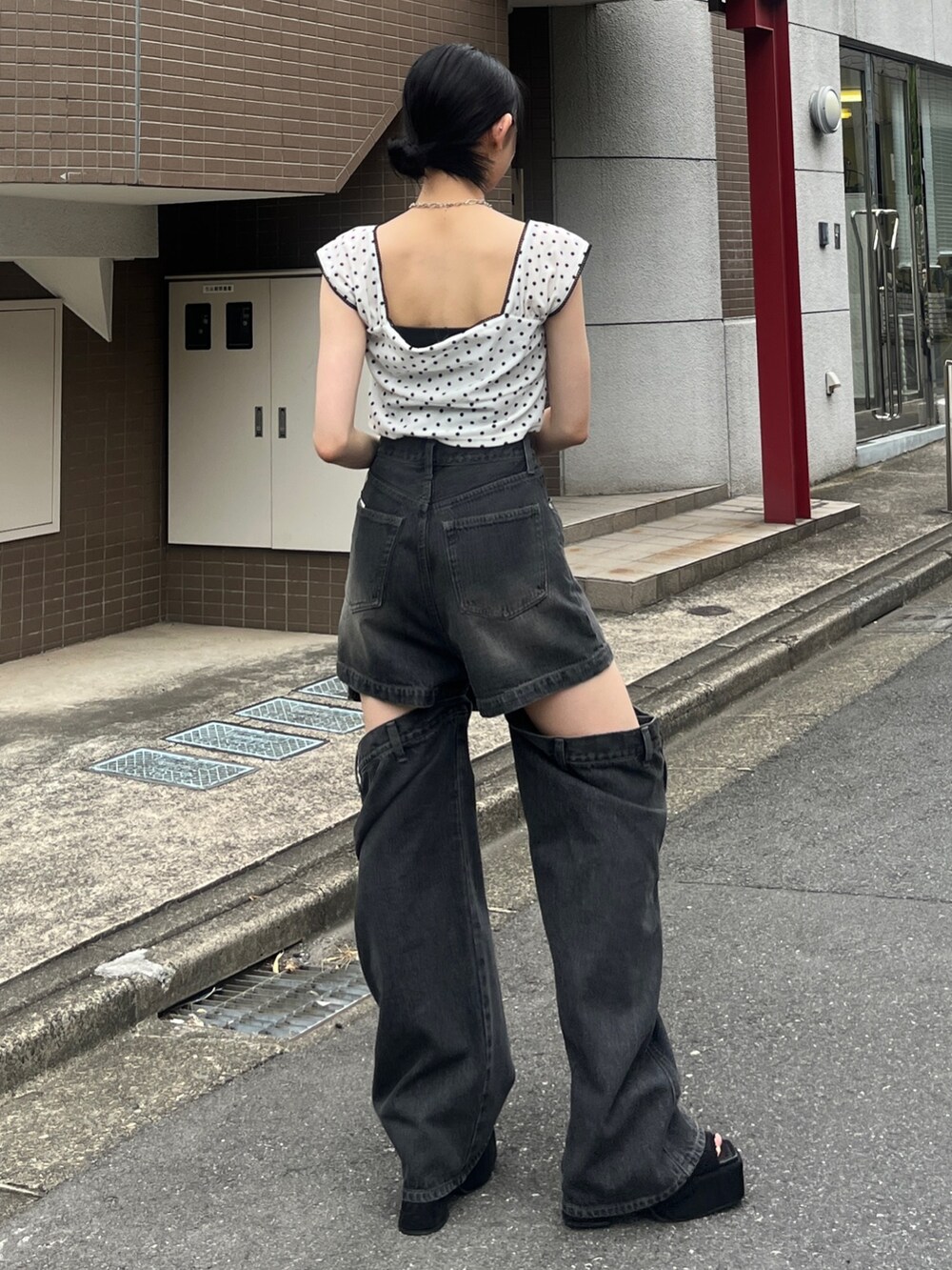 ホワイト系のタンクトップ、ブラック系のデニムパンツ、ブラック系のハンドバッグを着用したレディースの夏コーディネートの2枚目の写真