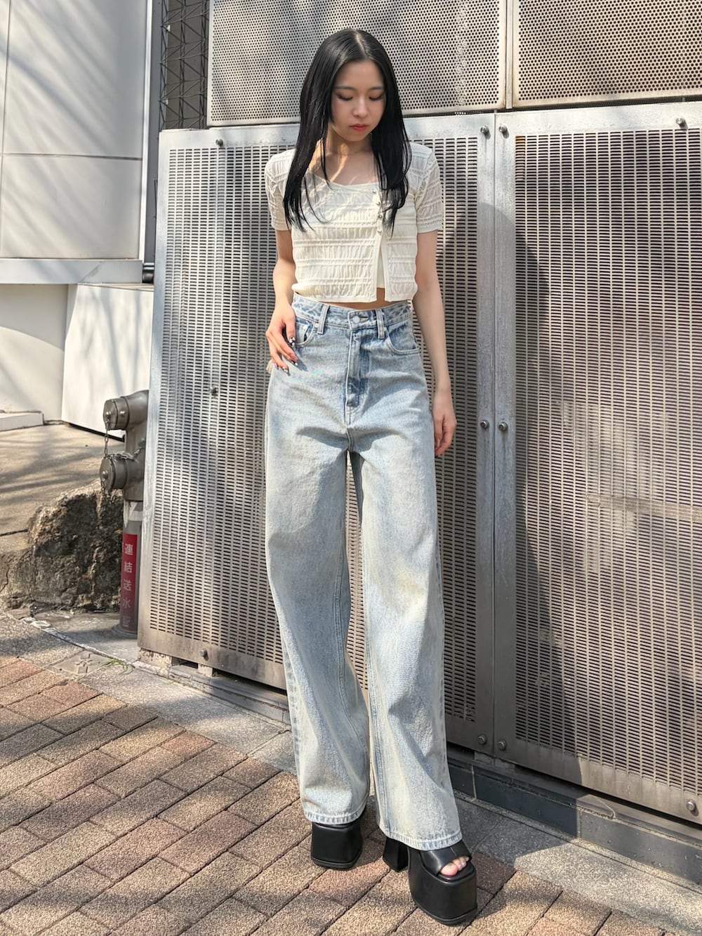 ブルー系のデニムパンツ、ブラック系のサンダルを着用したレディースの春コーディネートの2枚目の写真