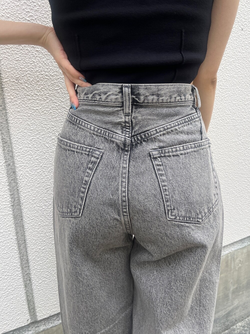 グレー系のデニムパンツ、ブラック系のサンダル、ブラック系のタンクトップを着用したレディースの春コーディネートの6枚目の写真