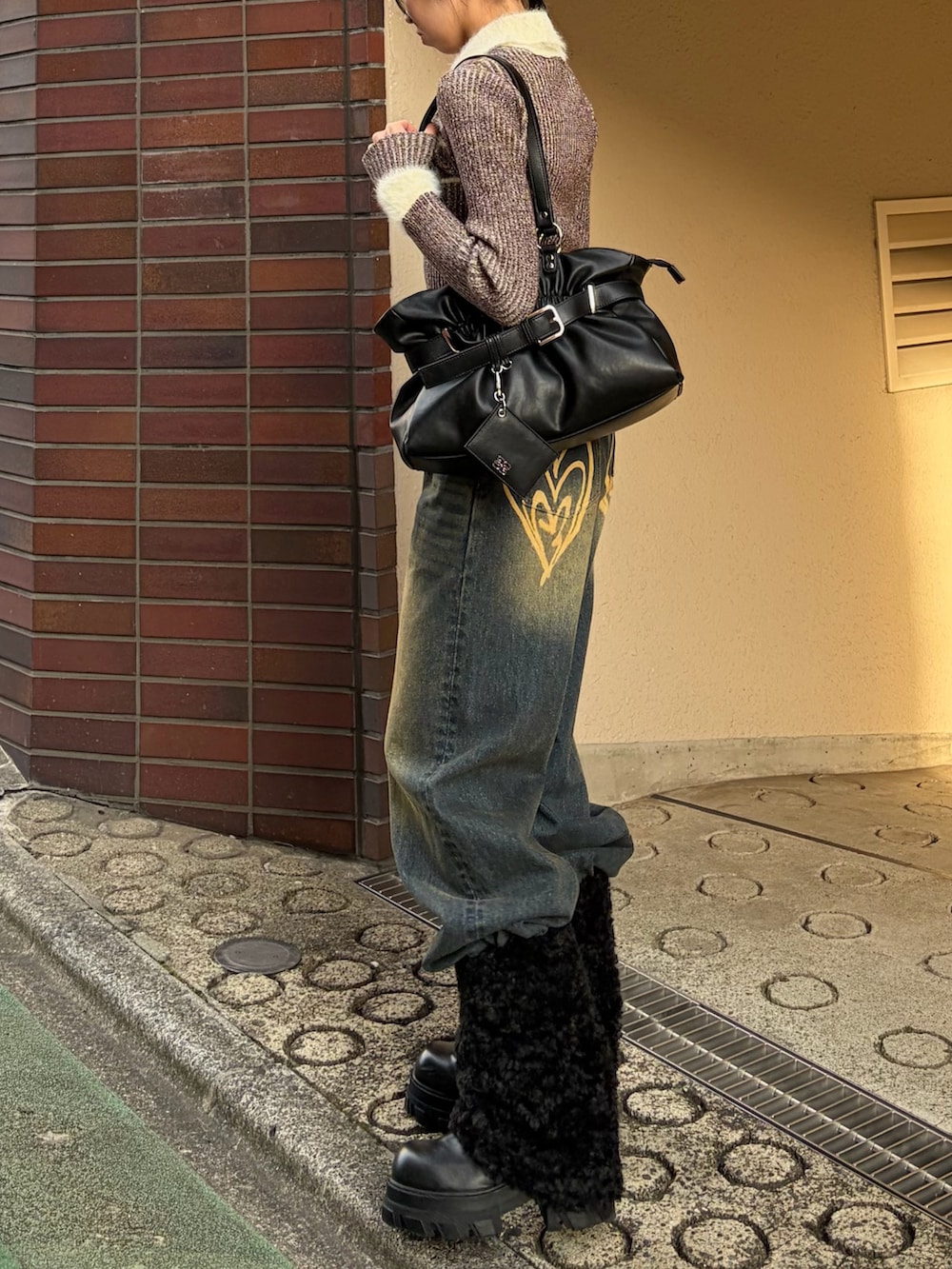 ブラウン系のニット/セーター、ブルー系のデニムパンツ、ブラック系のブーツを着用したレディースの冬コーディネートの2枚目の写真