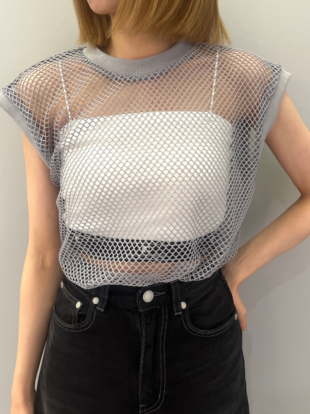 ブラック系のデニムパンツ、グレー系のTシャツ/カットソー、ホワイト系のサンダルを着用したレディースの夏コーディネートの5枚目の写真