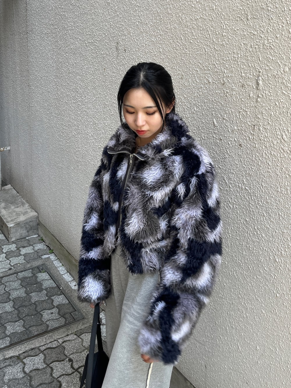 ブルー系のブルゾン、グレー系のスウェットパンツ、ブラック系のハンドバッグを着用したレディースの秋コーディネートの5枚目の写真