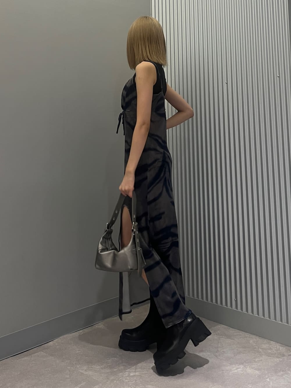 ブラック系のハンドバッグ、ブラック系のタンクトップ、その他のワンピースを着用したレディースの秋コーディネートの2枚目の写真