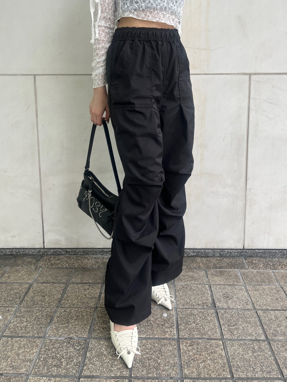ブラック系のその他パンツ、ブラック系のハンドバッグ、ホワイト系のパンプスを着用したレディースの春コーディネートの5枚目の写真