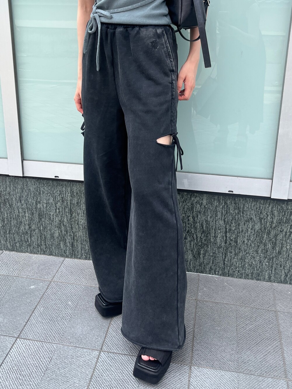 グレー系のTシャツ/カットソー、ブラック系のスウェットパンツ、ブラック系のハンドバッグを着用したレディースの夏コーディネートの4枚目の写真