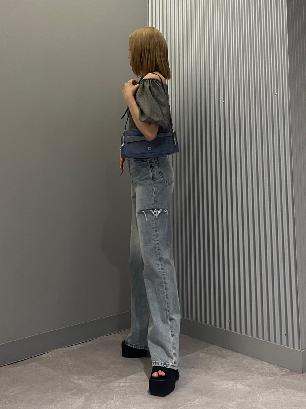 グレー系のシャツ/ブラウス、ブルー系のショルダーバッグ、ブルー系のデニムパンツを着用したレディースの夏コーディネートの2枚目の写真