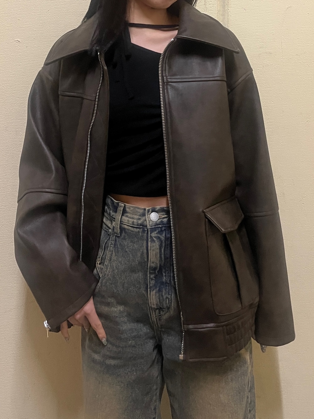 ブラック系のニット/セーター、ブラウン系のブルゾン、ブルー系のデニムパンツを着用したレディースの冬コーディネートの6枚目の写真