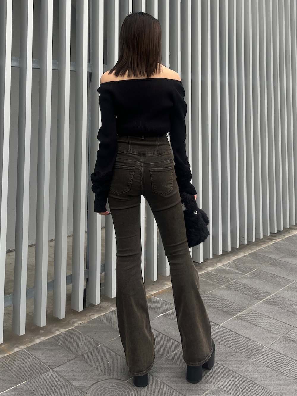 ブラック系のデニムパンツ、ブラウン系のブルゾン、ブラック系のハンドバッグを着用したレディースの秋コーディネートの3枚目の写真