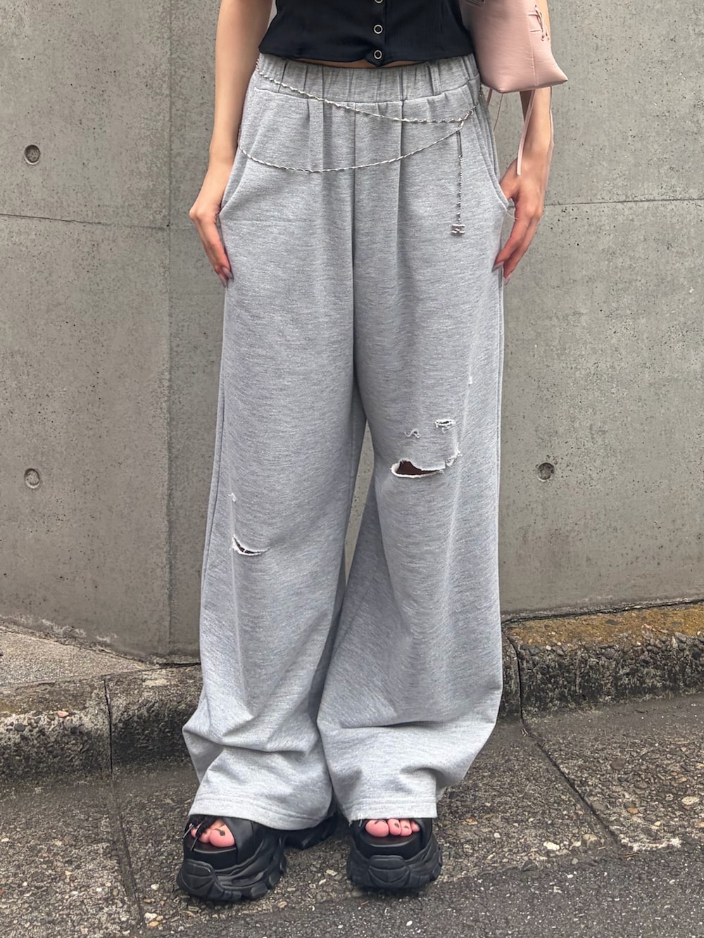 グレー系のスウェットパンツ、ブラック系のTシャツ/カットソー、ピンク系のショルダーバッグを着用したレディースの夏コーディネートの6枚目の写真