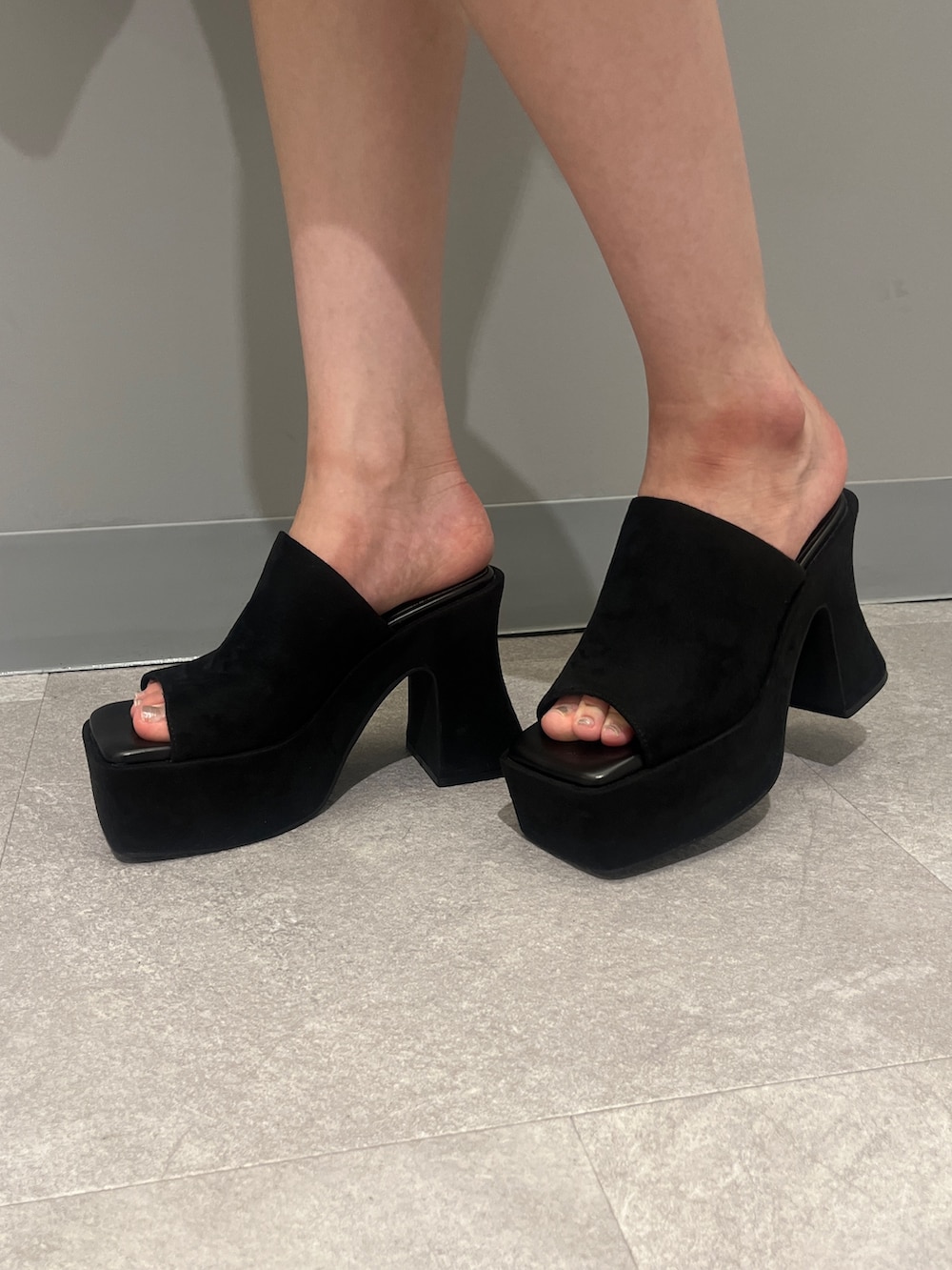 ブラック系のハンドバッグ、ブラック系のワンピース、ブラック系のサンダルを着用したレディースの夏コーディネートの6枚目の写真