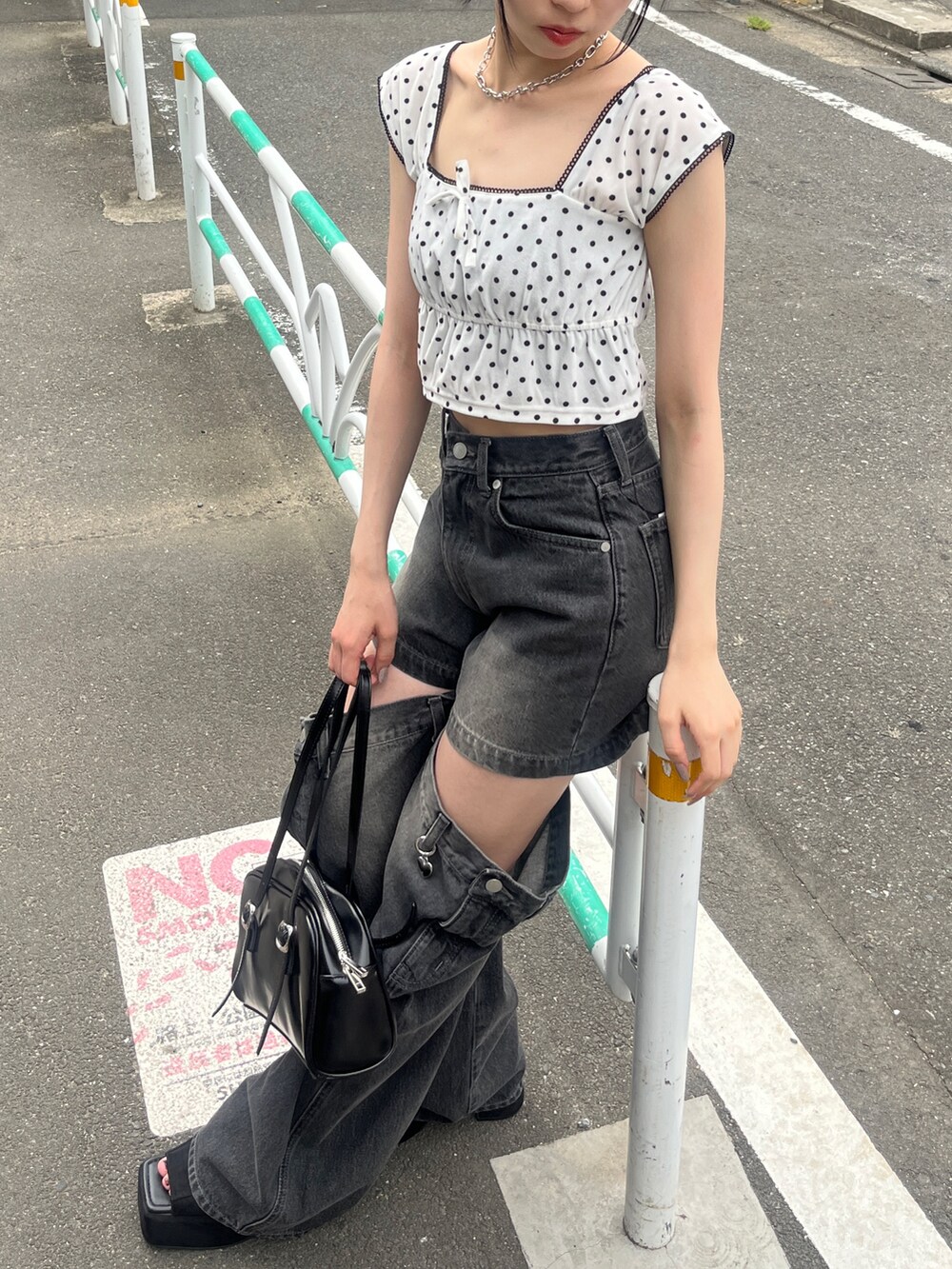 ホワイト系のタンクトップ、ブラック系のデニムパンツ、ブラック系のハンドバッグを着用したレディースの夏コーディネートの3枚目の写真