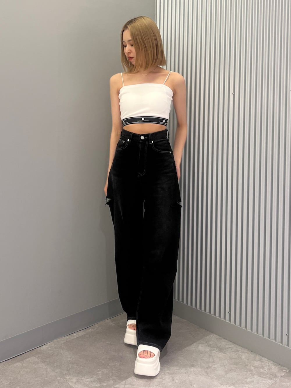 ブラック系のデニムパンツ、グレー系のTシャツ/カットソー、ホワイト系のサンダルを着用したレディースの夏コーディネートの4枚目の写真