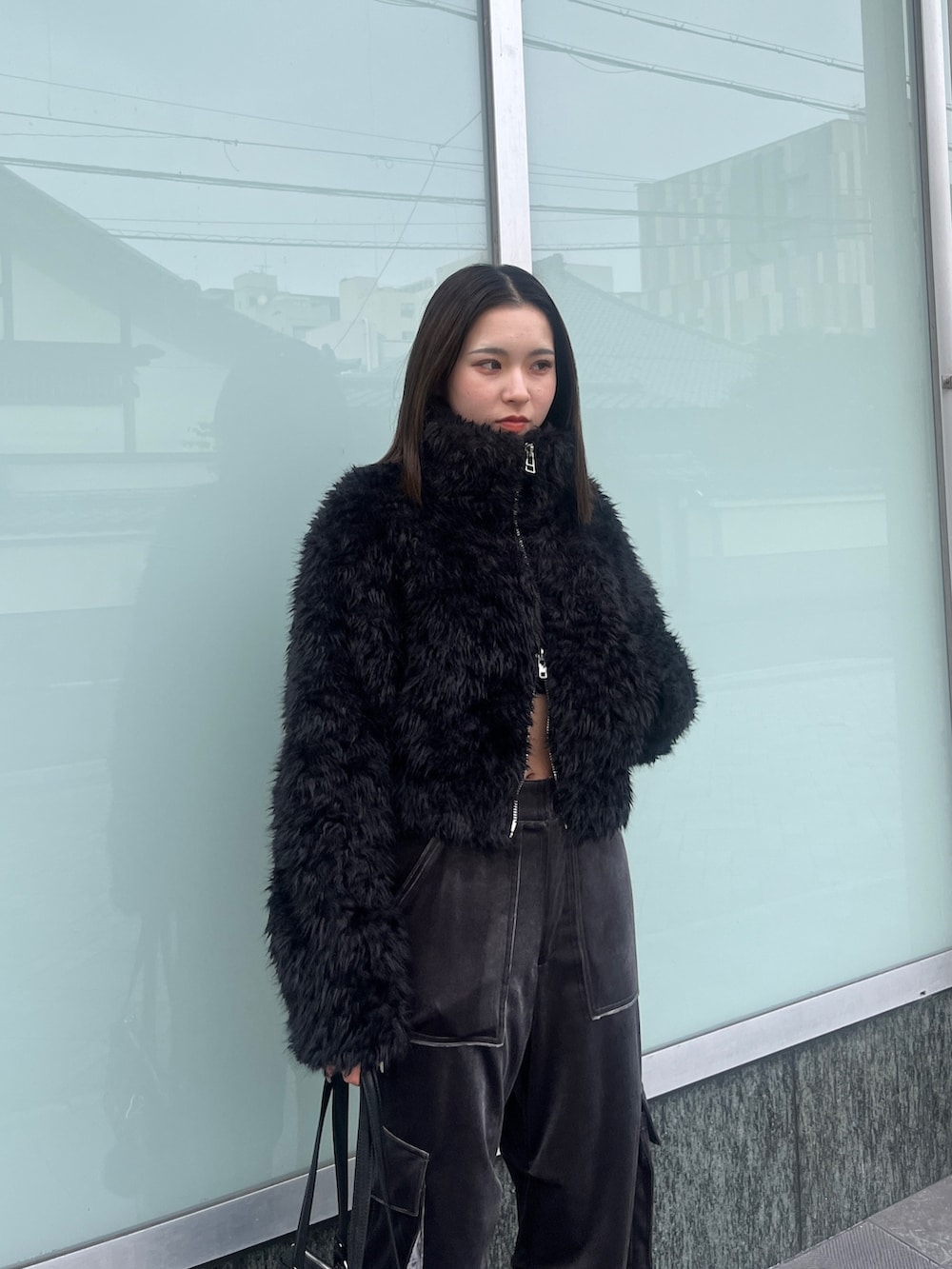 ブラック系のニット/セーター、ブラック系のブルゾン、グレー系のカーゴパンツを着用したレディースの秋コーディネートの5枚目の写真