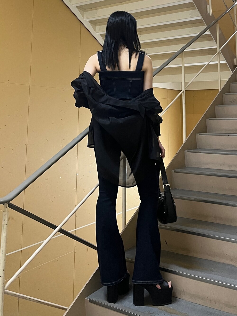 ブラック系のシャツ/ブラウス、ブルー系のサロペット/オーバーオール、ブラック系のハンドバッグを着用したレディースの春コーディネートの3枚目の写真