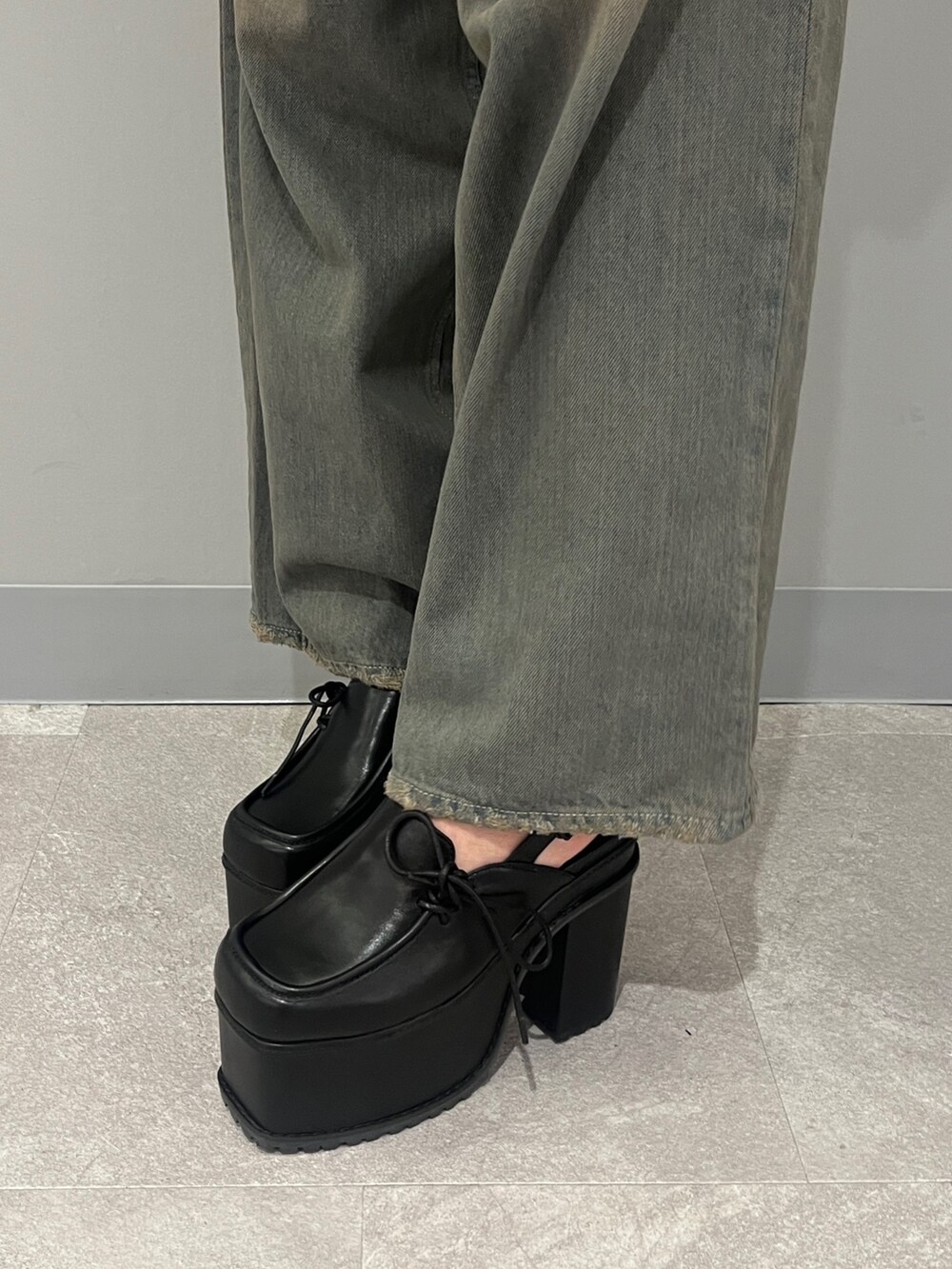 グレー系のデニムパンツ、ブラック系のサンダル、グレー系のデニムジャケットを着用したレディースの冬コーディネートの7枚目の写真