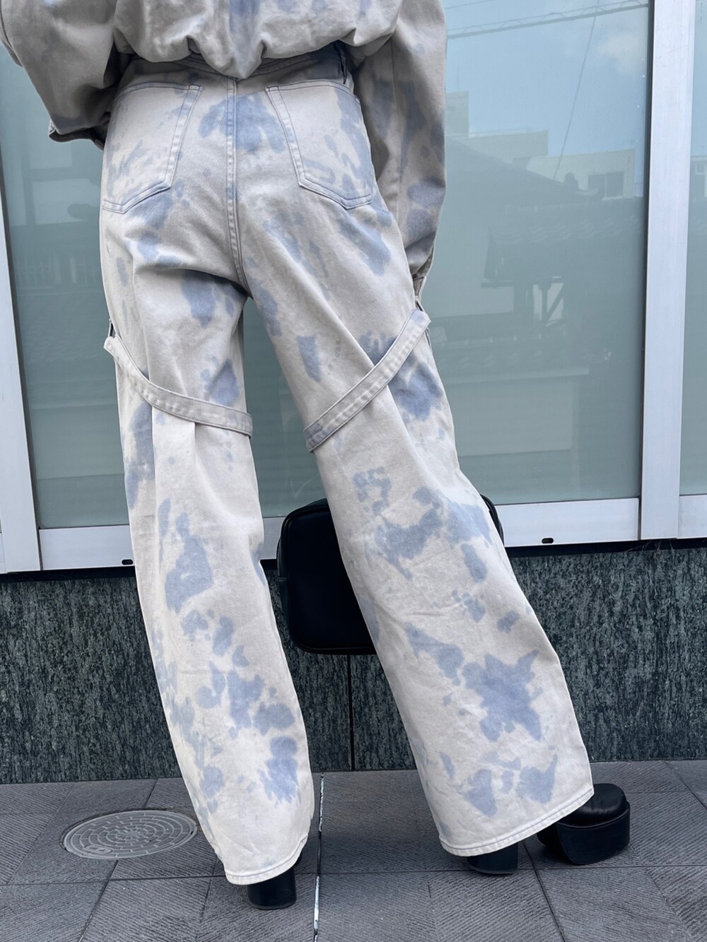 ホワイト系のデニムジャケット、ブラック系のニット/セーター、ホワイト系のデニムパンツを着用したレディースの冬コーディネートの6枚目の写真