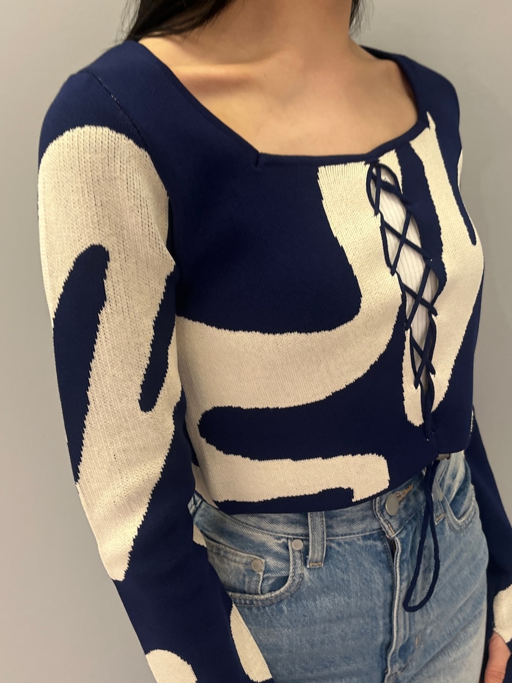 ブルー系のデニムパンツ、ブラック系のブーツ、グリーン系のキャミソールを着用したレディースの冬コーディネートの4枚目の写真