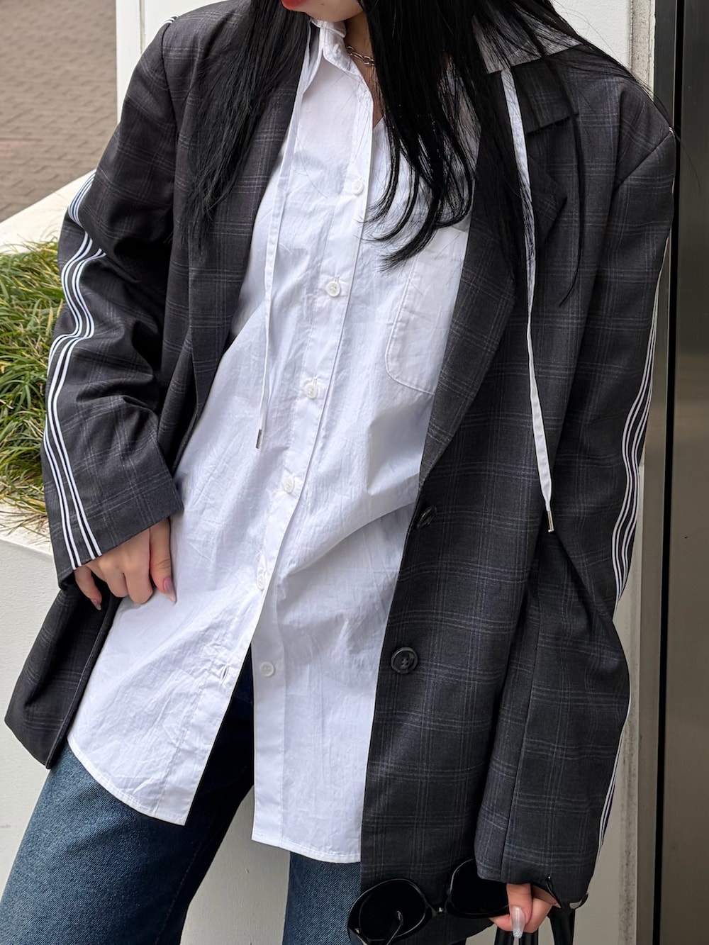 グレー系のテーラードジャケット、ホワイト系のシャツ/ブラウス、ブルー系のデニムパンツを着用したレディースの春コーディネートの7枚目の写真