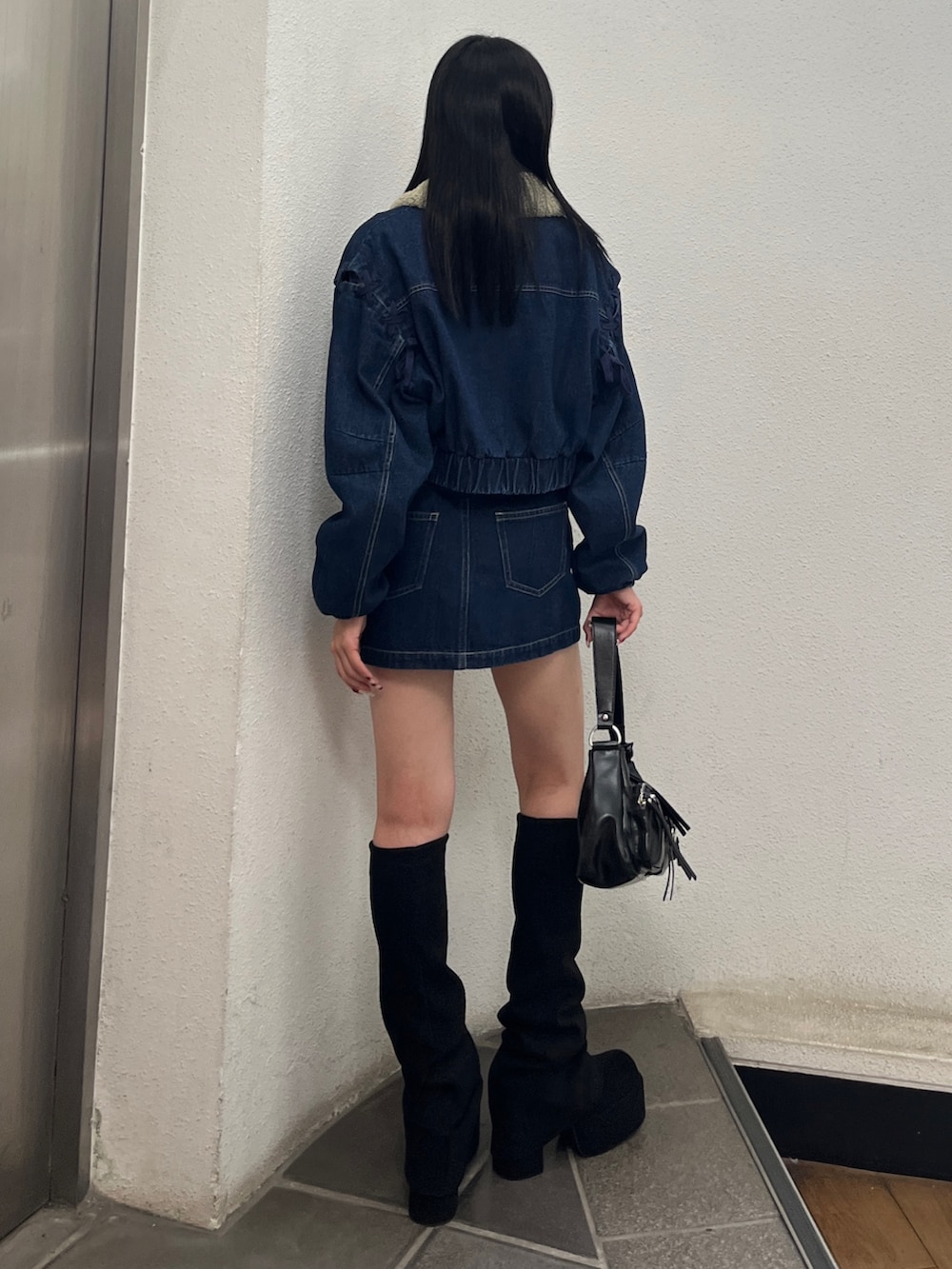 ブルー系のスカート、ブルー系のブルゾン、ホワイト系のTシャツ/カットソーを着用したレディースの秋コーディネートの3枚目の写真