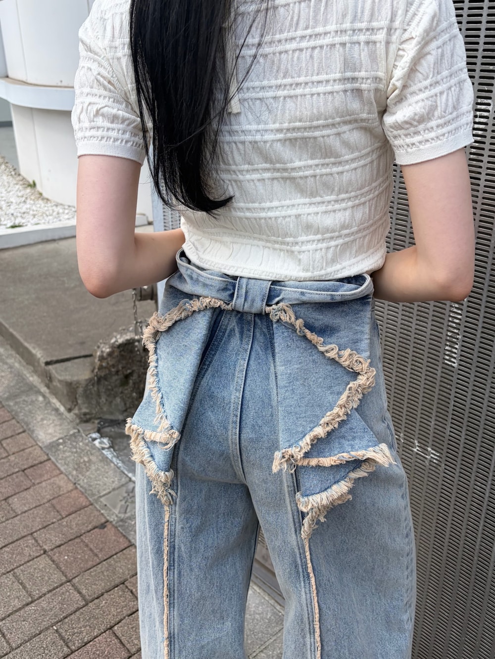 ブルー系のデニムパンツ、ブラック系のサンダルを着用したレディースの春コーディネートの5枚目の写真