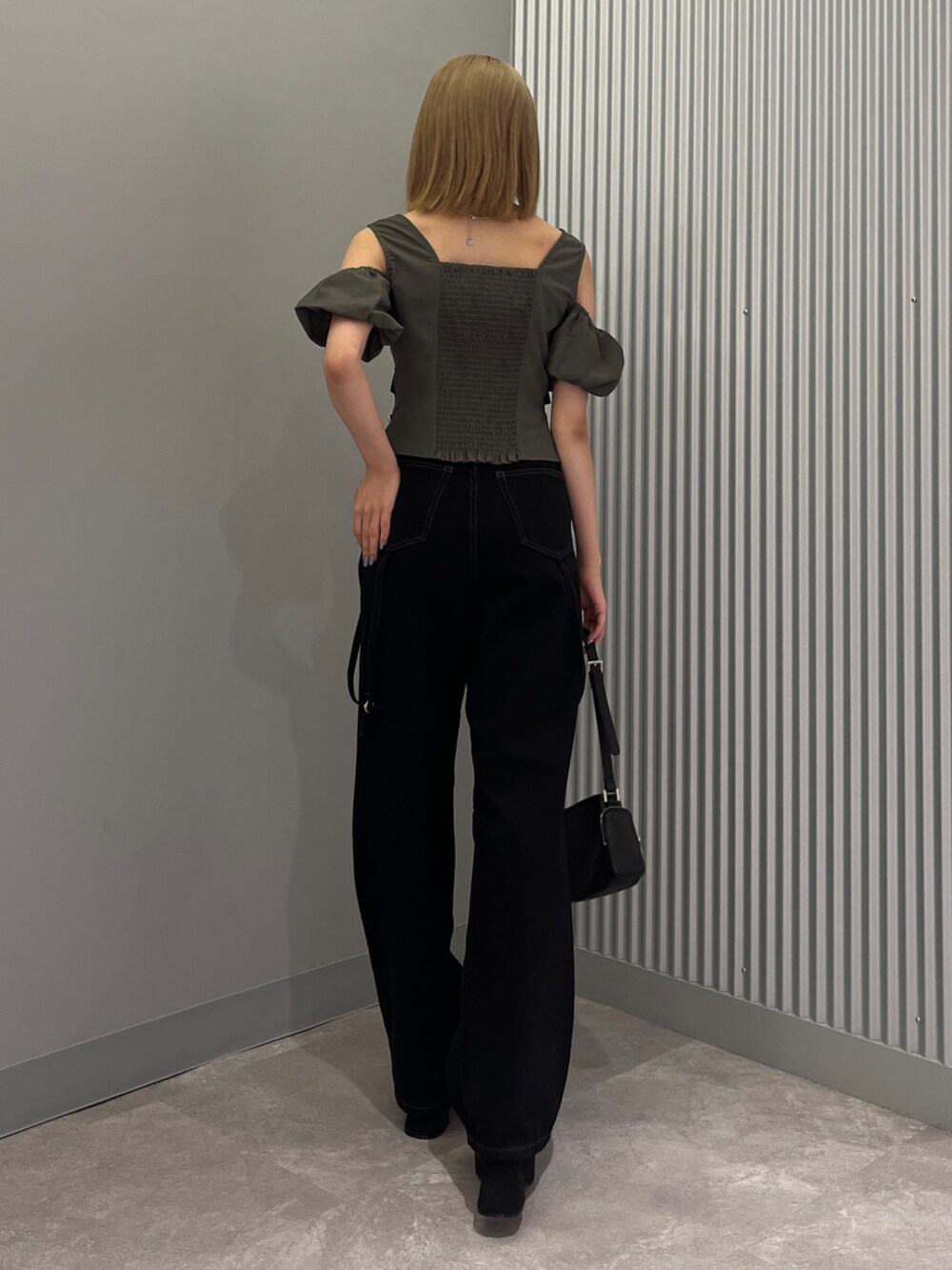 ブラック系のデニムパンツ、ブラック系のショルダーバッグ、ブラック系のサンダルを着用したレディースの夏コーディネートの3枚目の写真