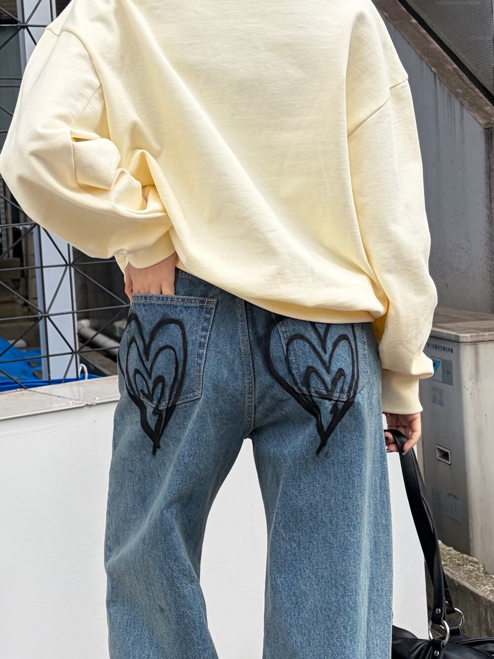 ホワイト系のパーカー、ブルー系のデニムパンツ、ブラック系のトートバッグを着用したレディースの冬コーディネートの5枚目の写真