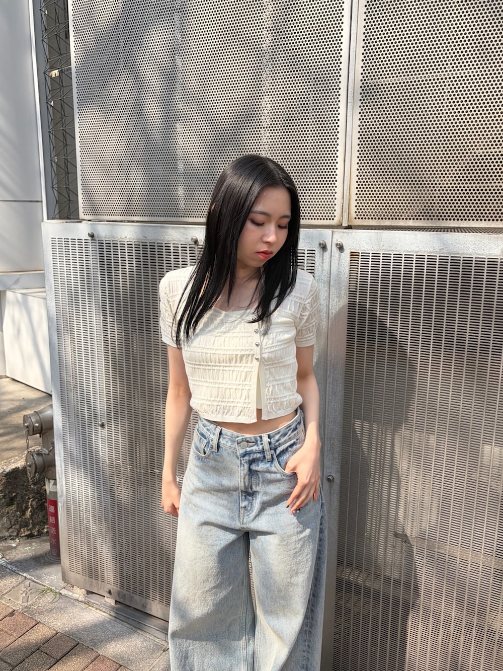 ブルー系のデニムパンツ、ブラック系のサンダルを着用したレディースの春コーディネートの3枚目の写真