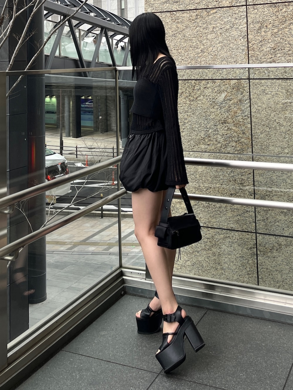 ブラック系のニット/セーター、ブラック系のスカート、ブラック系のサンダルを着用したレディースの春コーディネートの2枚目の写真