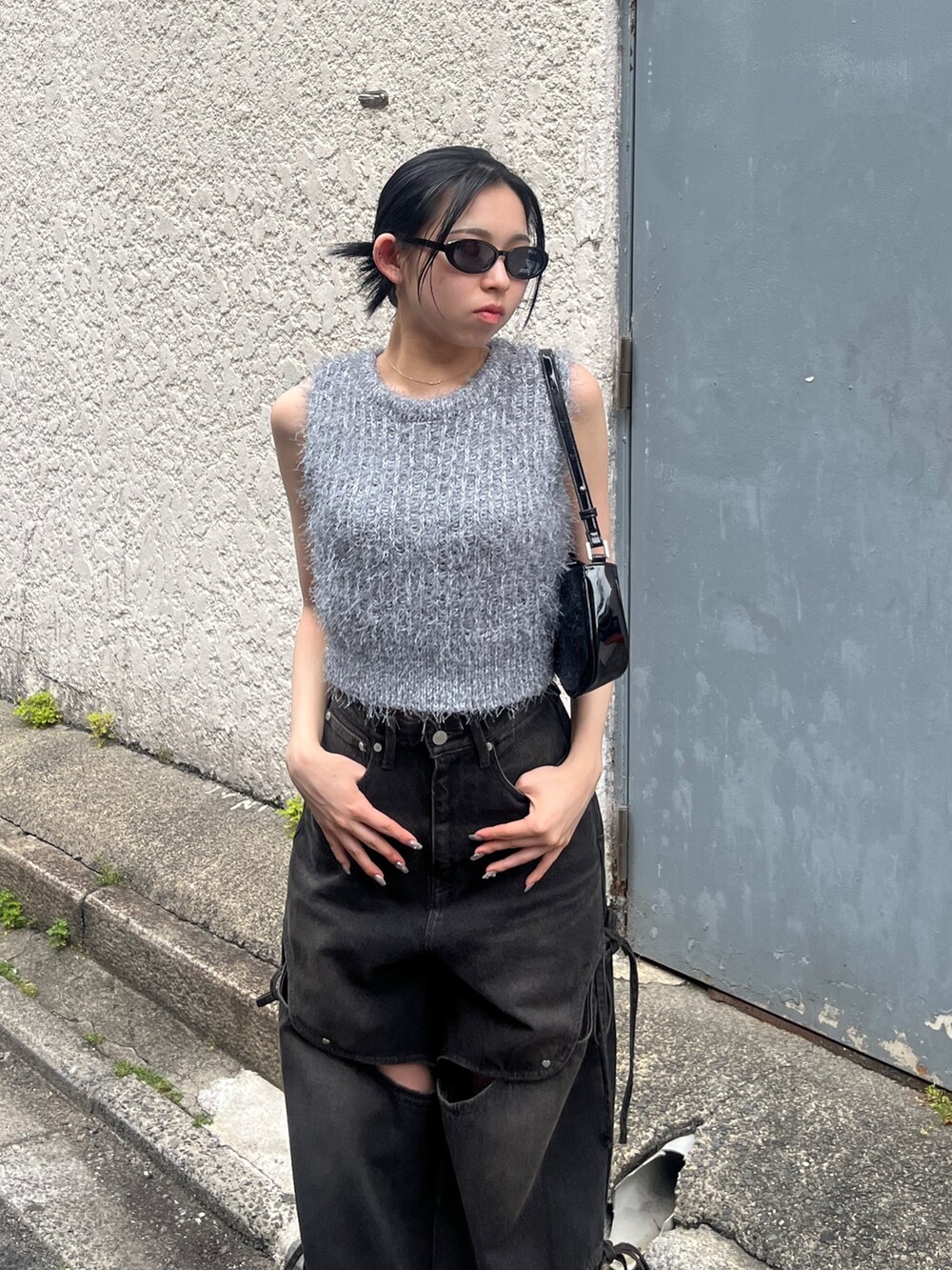 ブラック系のデニムパンツ、ブラック系のサンダル、グレー系のニット/セーターを着用したレディースの春コーディネートの4枚目の写真