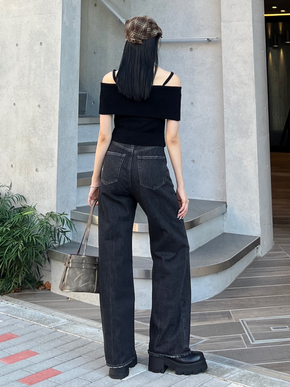 ブラック系のニット/セーター、ブラック系のデニムパンツ、ブラウン系のショルダーバッグを着用したレディースの夏コーディネートの2枚目の写真