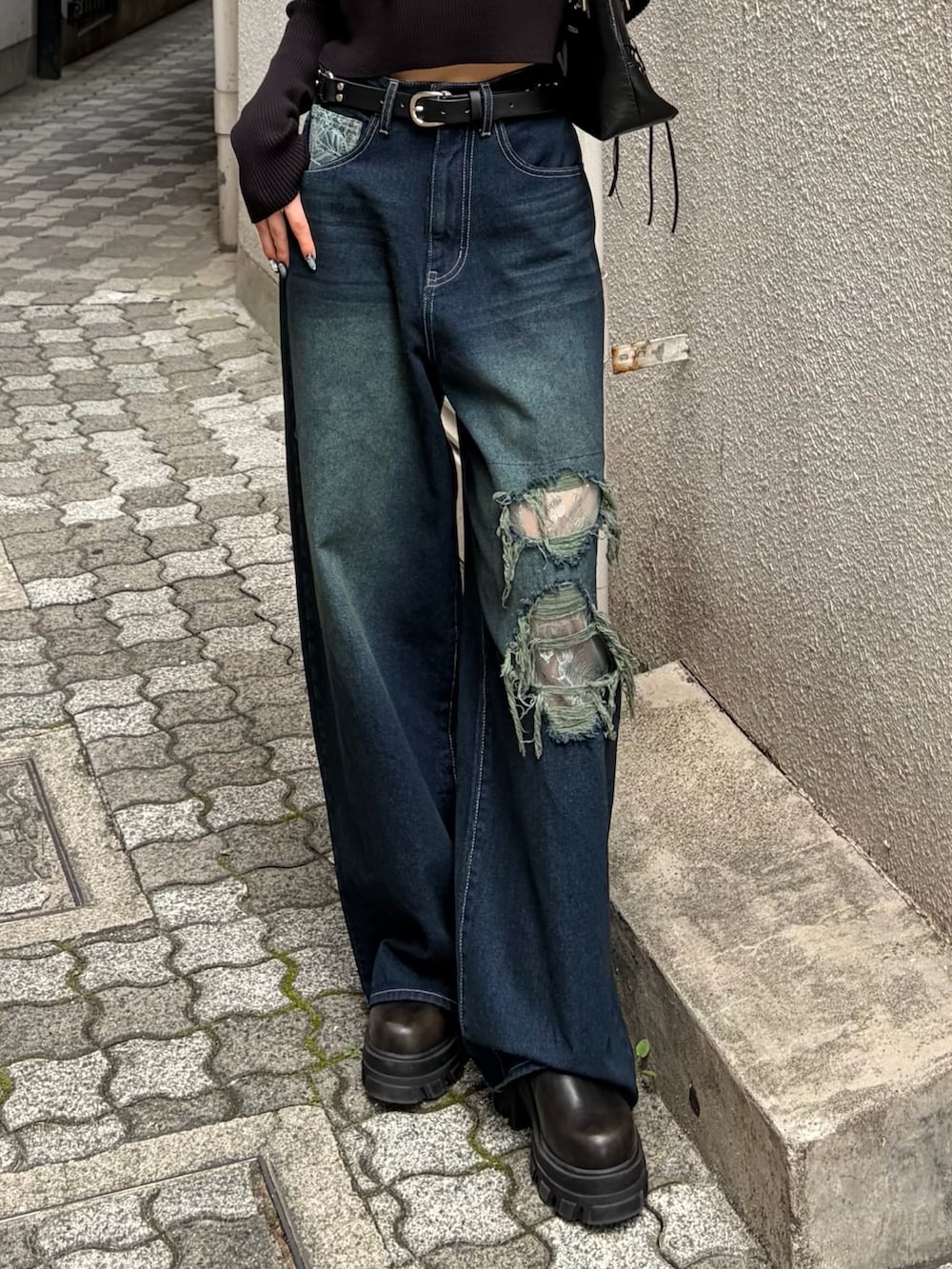 ブラック系のニット/セーター、ブルー系のデニムパンツ、ブラック系のショルダーバッグを着用したレディースの秋コーディネートの6枚目の写真