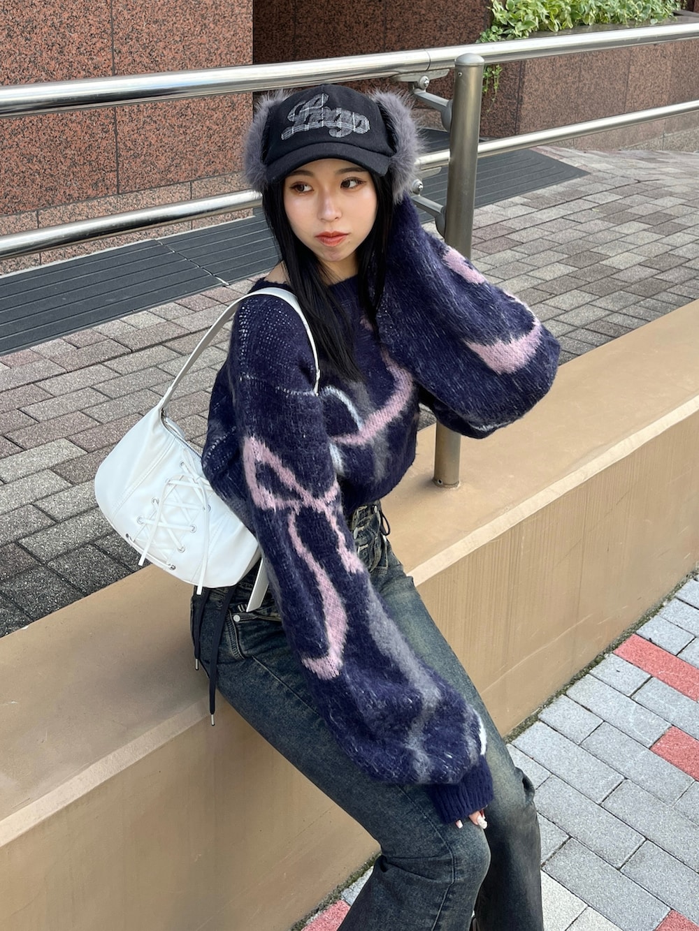 ブルー系のニット/セーター、ブルー系のデニムパンツ、ホワイト系のショルダーバッグを着用したレディースの秋コーディネートの5枚目の写真