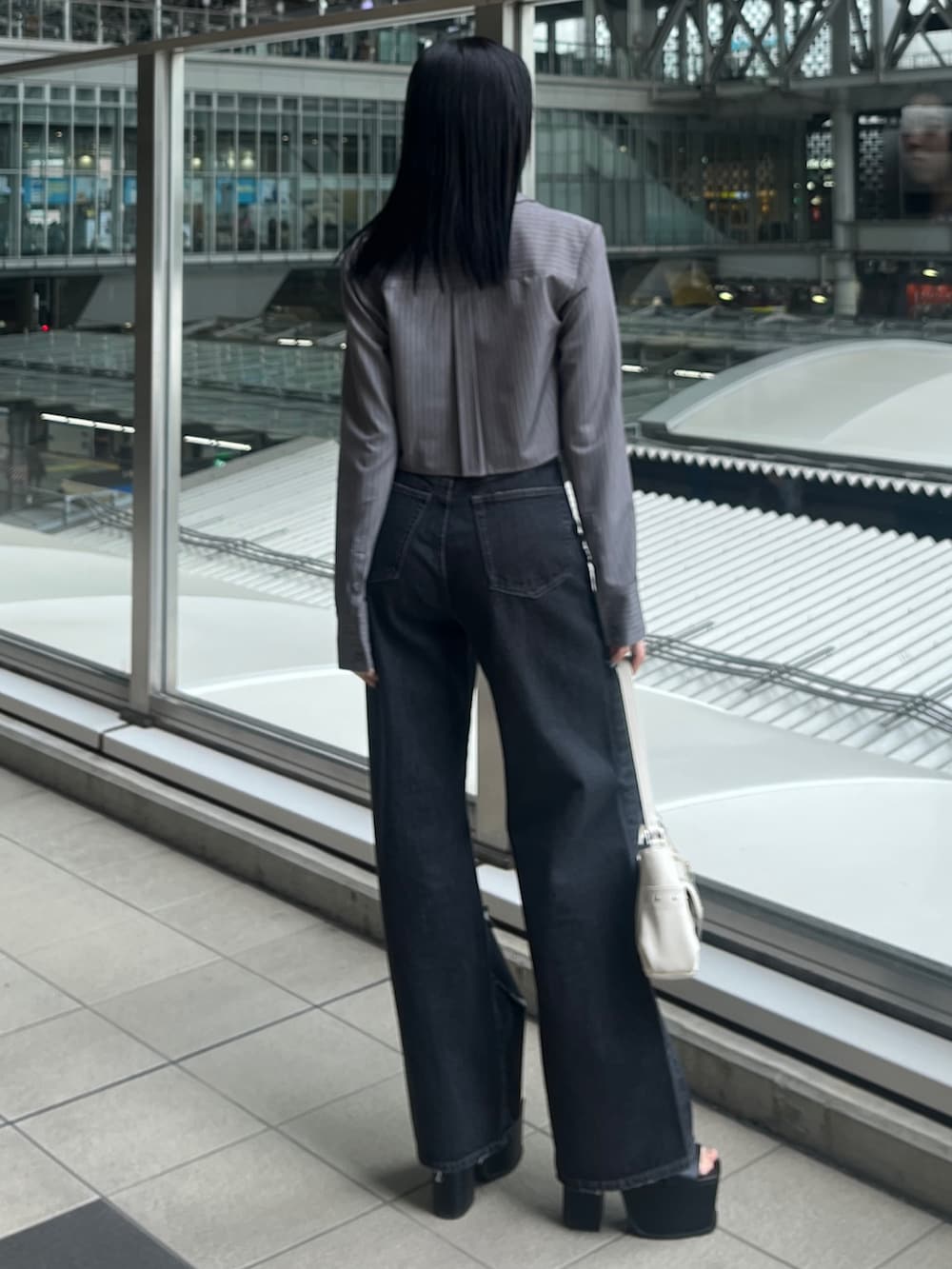 グレー系のシャツ/ブラウス、ブラック系のデニムパンツ、ブラック系のサンダルを着用したレディースの春コーディネートの3枚目の写真