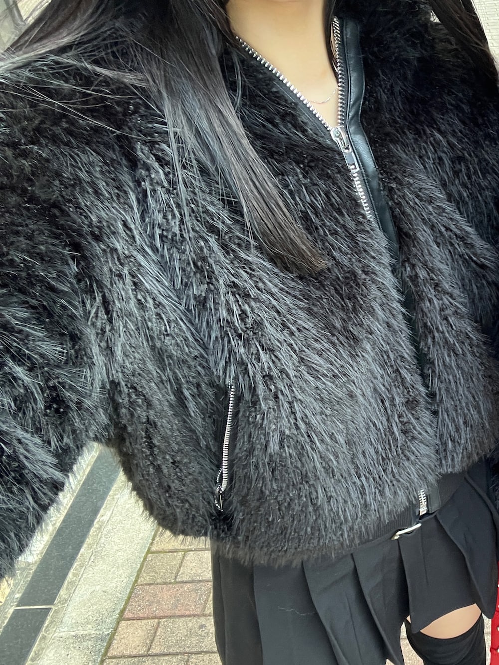 ブラック系のスカート、ブラック系のブルゾン、レッド系のショルダーバッグを着用したレディースの秋コーディネートの5枚目の写真