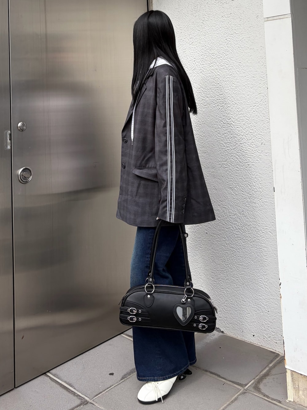 グレー系のテーラードジャケット、ホワイト系のシャツ/ブラウス、ブルー系のデニムパンツを着用したレディースの春コーディネートの4枚目の写真