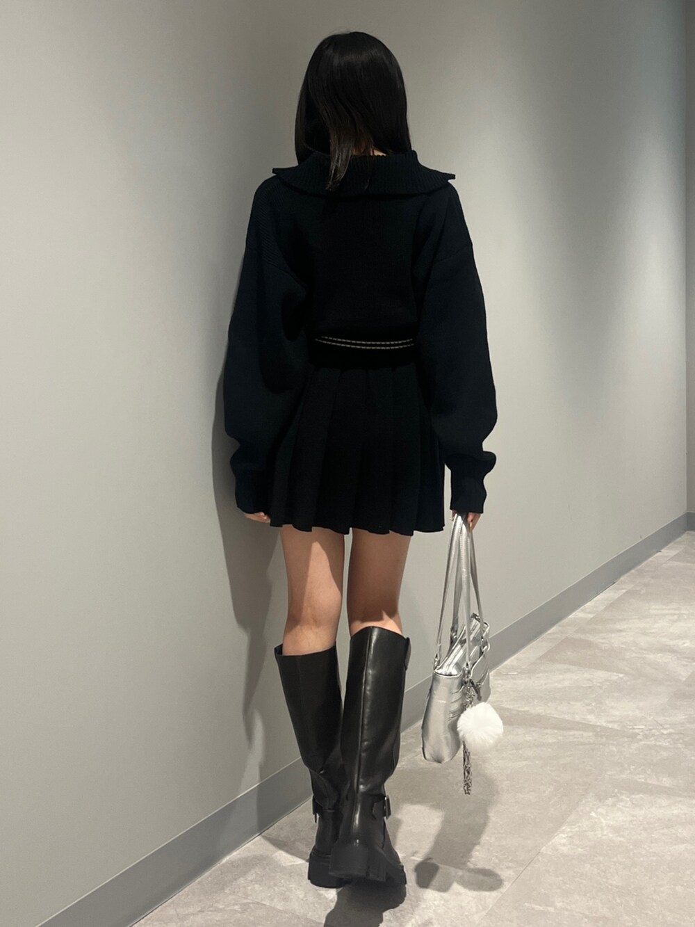 ブラック系のニット/セーター、ブラック系のスカート、ブラック系のブーツを着用したレディースの秋コーディネートの3枚目の写真