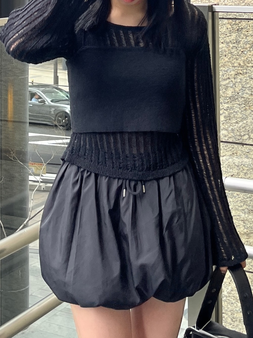 ブラック系のニット/セーター、ブラック系のスカート、ブラック系のサンダルを着用したレディースの春コーディネートの4枚目の写真