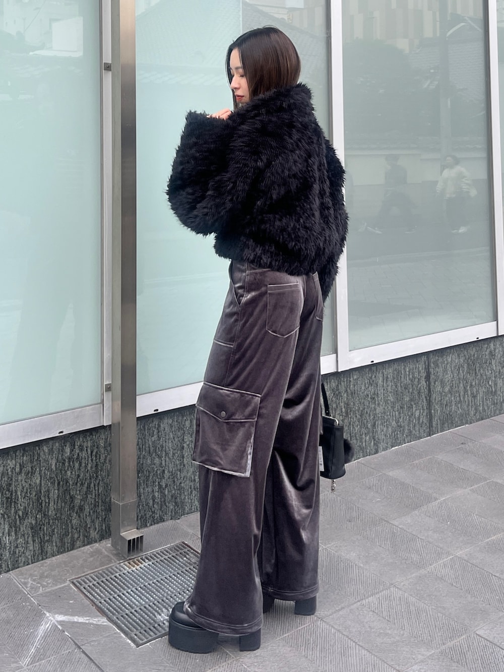 ブラック系のニット/セーター、ブラック系のブルゾン、グレー系のカーゴパンツを着用したレディースの秋コーディネートの2枚目の写真